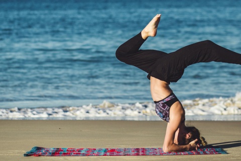 Chica practicando yoga en la playa