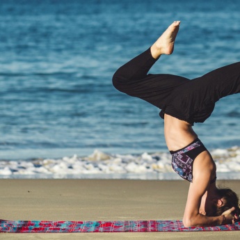 Frau beim Yoga am Strand