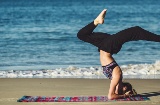Girl practising yoga on the beach