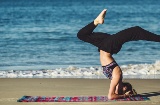 Frau beim Yoga am Strand